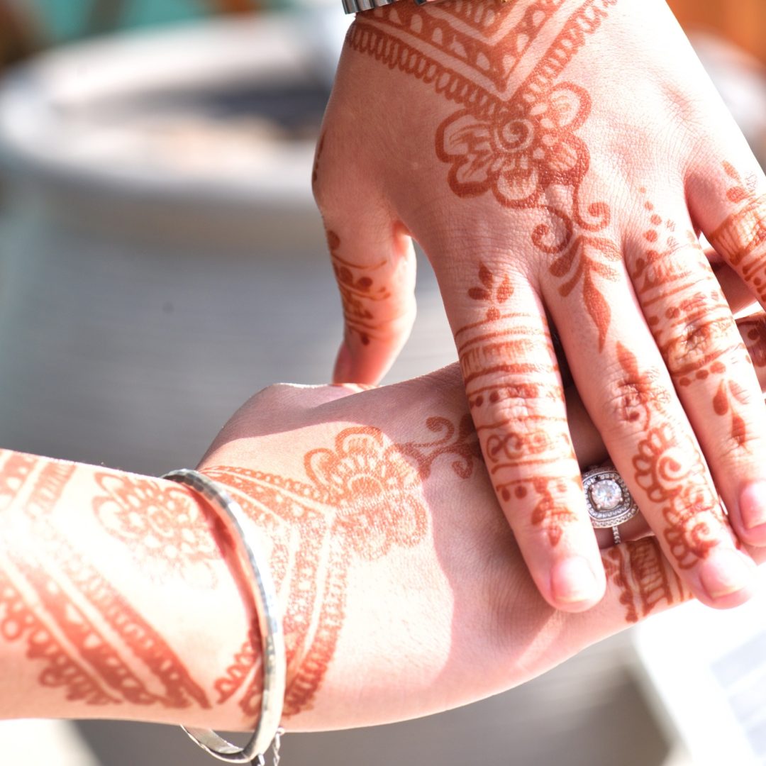 Beautiful henna art on a young unrecognizable gen z woman’s hands in afternoon sunlight