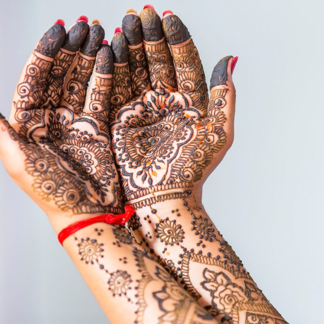 Closeup shot of female hands painted with mehndi