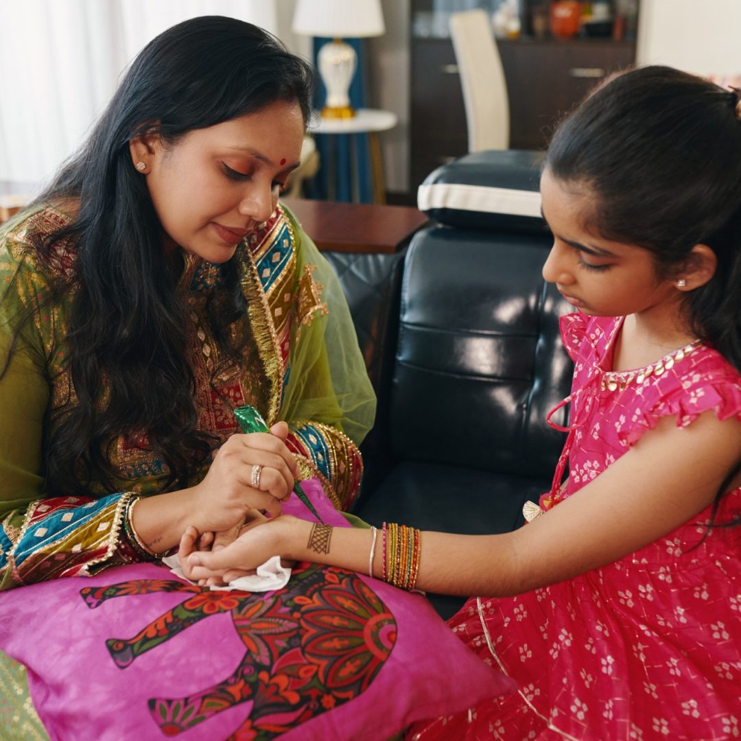 Mom Making Ornament On Hand From Henna